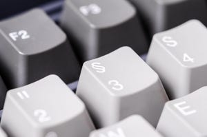 Close-up of grey computer keyboard with symbols.