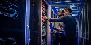 Two data center engineers in front of data center equipment.