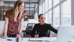 two women working together at a laptop